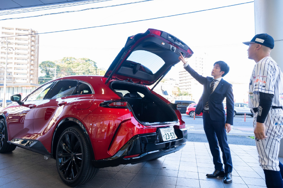 ネッツトヨタ北九州小倉本店にて新型クラウン(スポーツ)の ハンズフリーパワーバックドア の説明を受ける中村道大郎選手